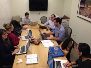Six people sit around a conference room table.