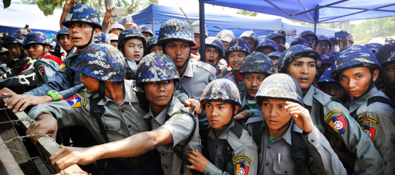Police officers stationed behind a barbed-wire barricade in Letpadan, March 10, 2015. Police constructed barricades to obstruct protesters from marching to Yangon, violating their human right to peaceful assembly. ©2015 Steve Tickner/The Irrawaddy.
