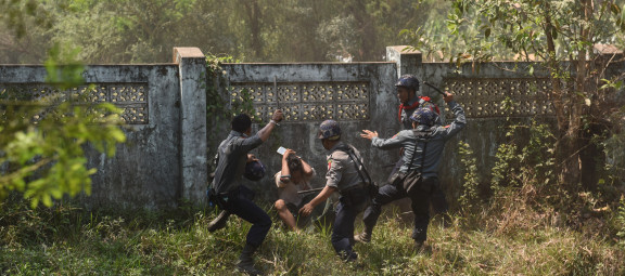 Multiple police officers use batons to beat a single, squatting protester as he attempts to protect his head from being struck, Letpadan, Bago Region, March 10, 2015. ©2015 Sai Zaw/The Irrawaddy.