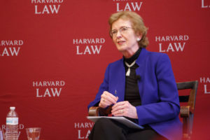 Mary Robinson speaks in front of a backdrop covered in Harvard Law School's logo.