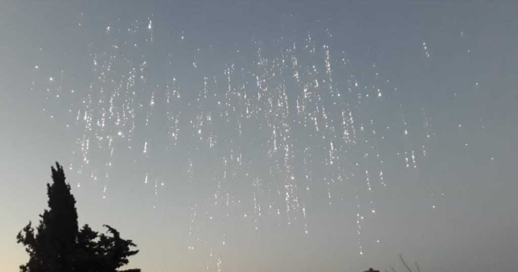 Picture shows the use of an incendiary weapon showering from the sky.