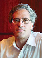 Peter Rosenblum in a white shirt and oval glasses looking to the camera